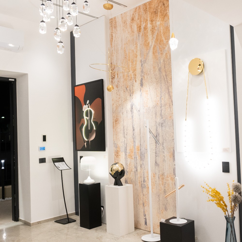 Lampade a sospensione e illuminazione diffusa in ambiente showroom con finiture pregiate